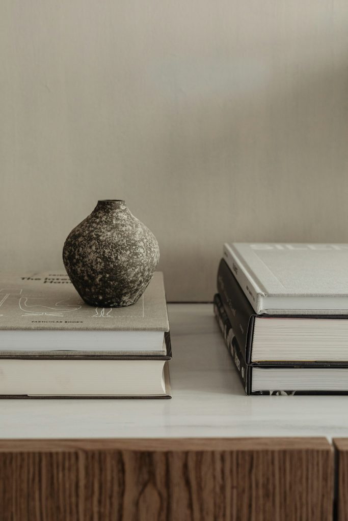 Vase and stacked books styled on a surface